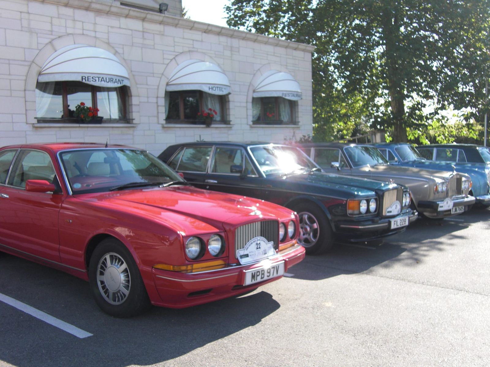 Bentley et Rolls-Royce alignées devant la façade